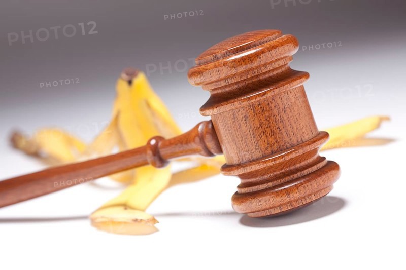 Gavel and banana peel on gradated background with selective focus