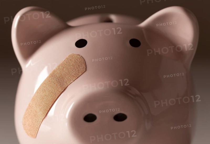 Piggy bank with bandage on face on gradated background