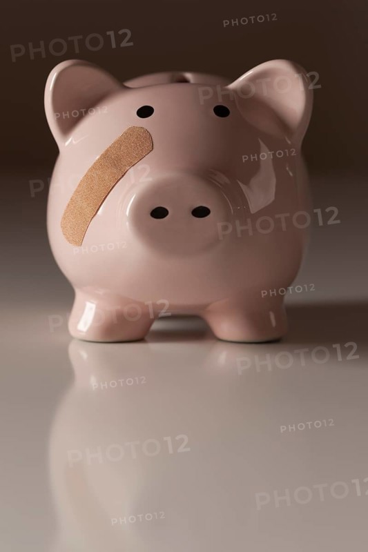 Piggy bank with bandage on face on gradated background