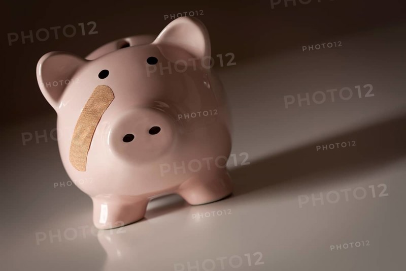 Piggy bank with bandage on face on gradated background