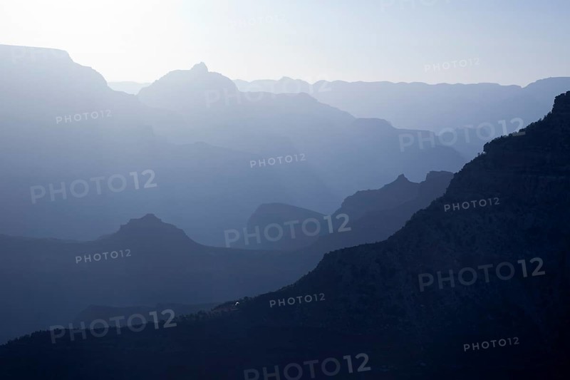 Scenic layers of the grand canyon in the early morning with hikers cabin roof shining in the lower middle