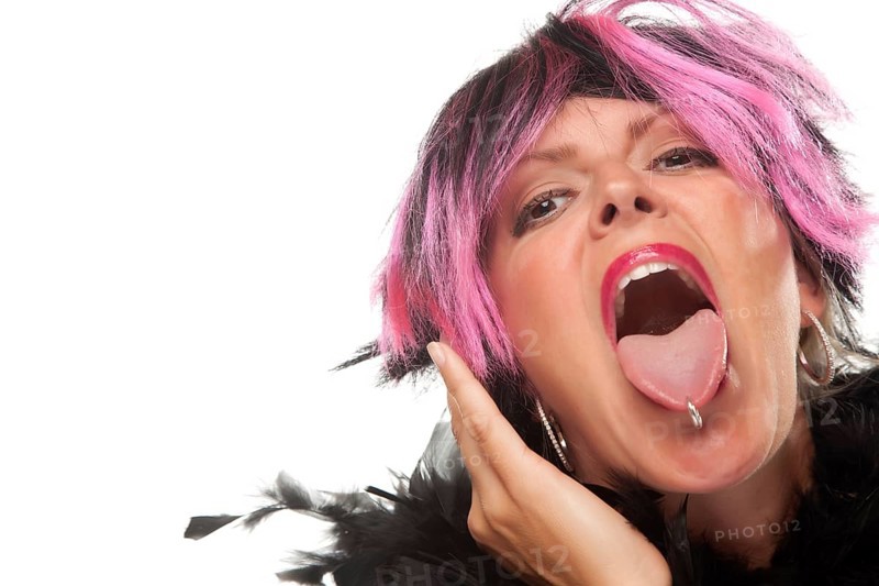 Pink and black haired girl sticking her pierced tongue out isolated on a white background
