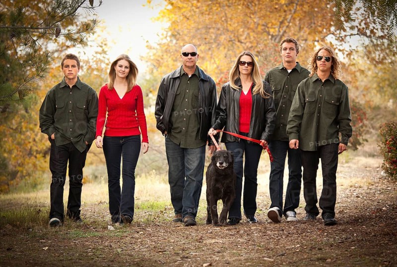 Attractive family portrait walking outdoors with their dog