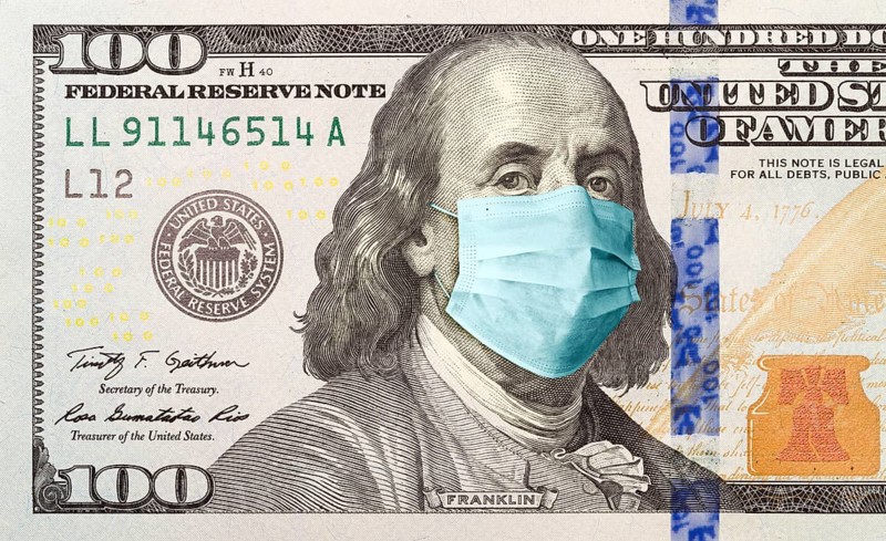 One hundred dollar bill with medical face mask on benjamin franklin