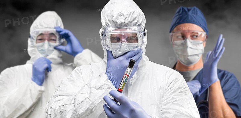 Team of doctors or nurses in hazmat gear holding positive coronavirus test tube banner