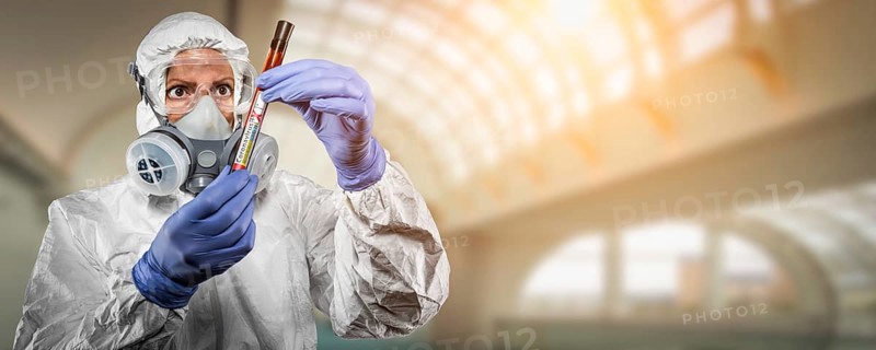 Female doctor or nurse in hazmat gear holding positive coronavirus test tube banner