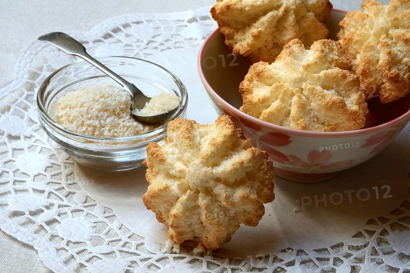 Coconut macaroons and coconut flakes in bowls