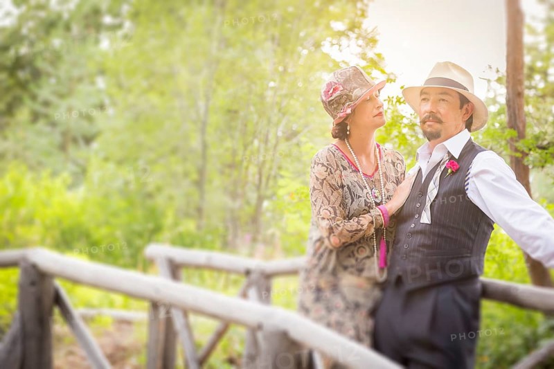 Attractive 1920s dressed romantic couple on wooden bridge