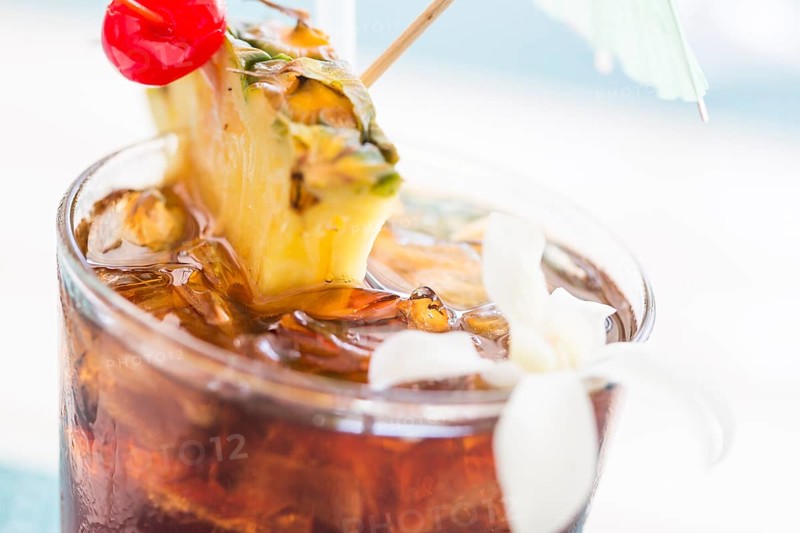 Ice cold mai tai cocktail drink with fruit and umbrellas at the bar