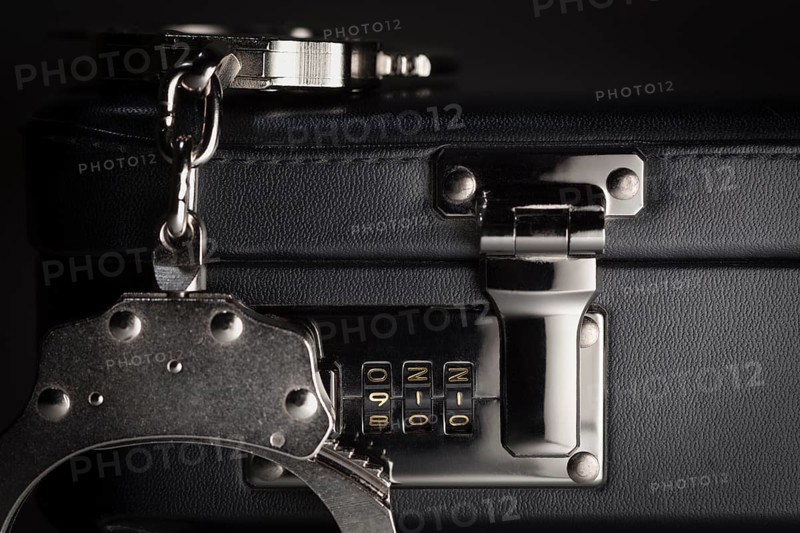Pair of handcuffs on briefcase with the numbers 911 on lock