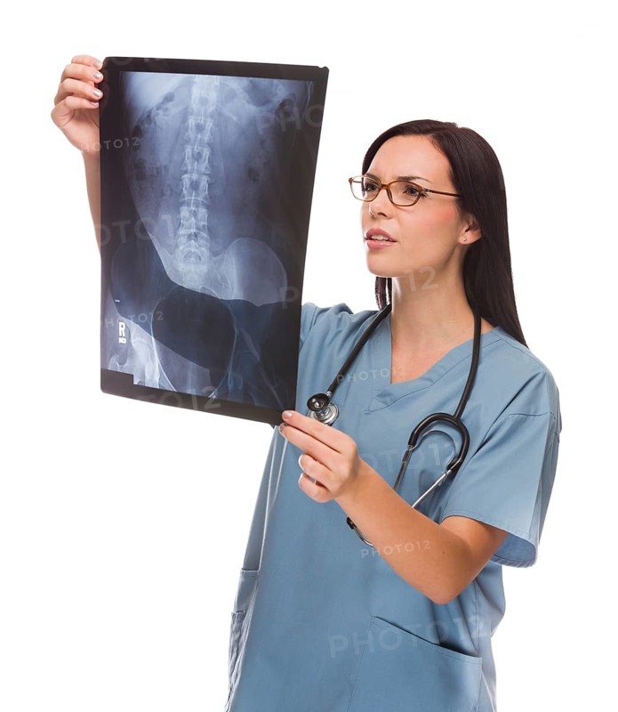 Attractive mixed-race female nurse or doctor wearing scrubs and stethoscope reviewing an x-ray isolated on a white background