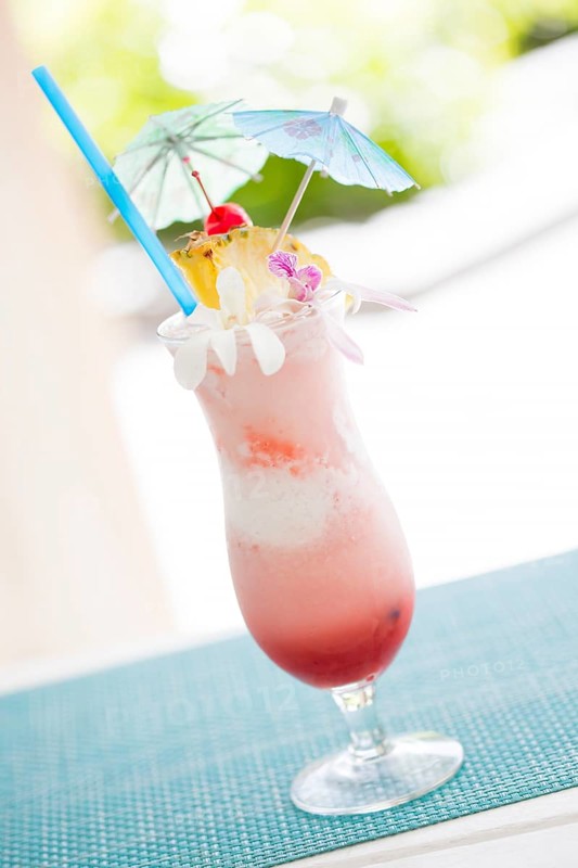 Fruity tropical drink with pineapple and umbrellas at the bar