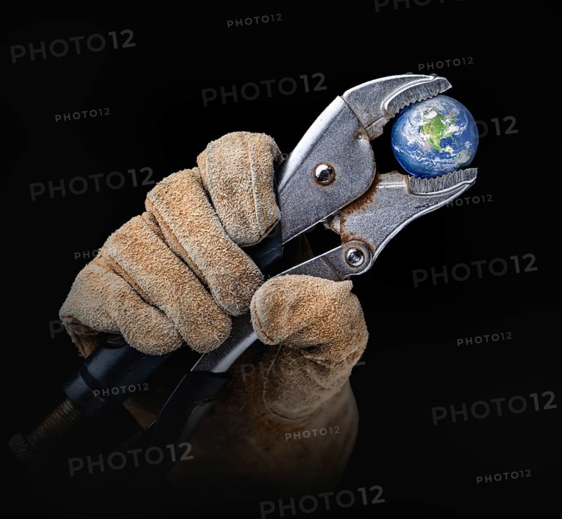Worker in construction gloves holding planet earth with vise-grip wrench