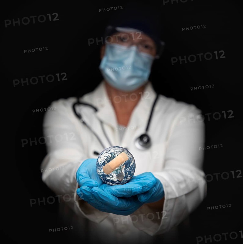 Nurse or doctor wearing face mask and surgical gloves holding bandaged planet earth