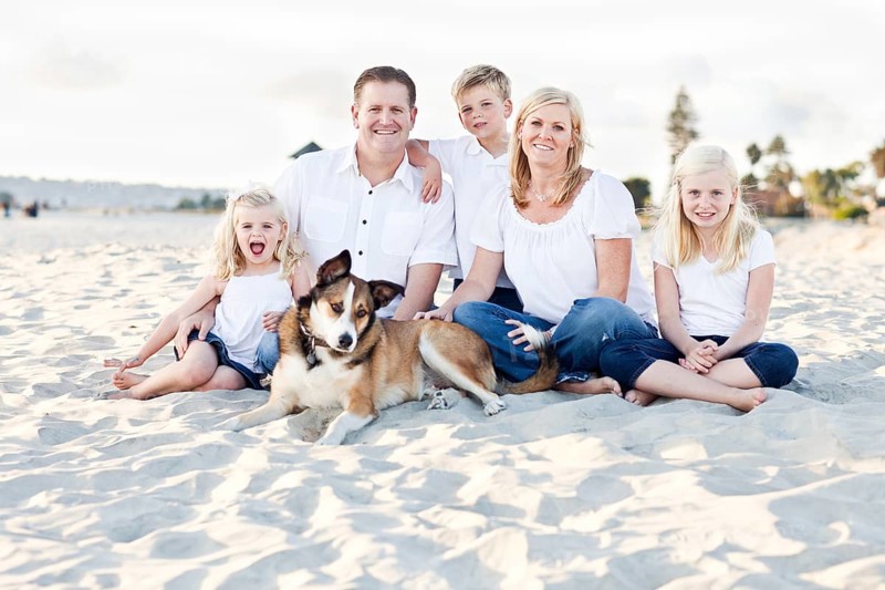 Happy caucasian family and their dog at the beach