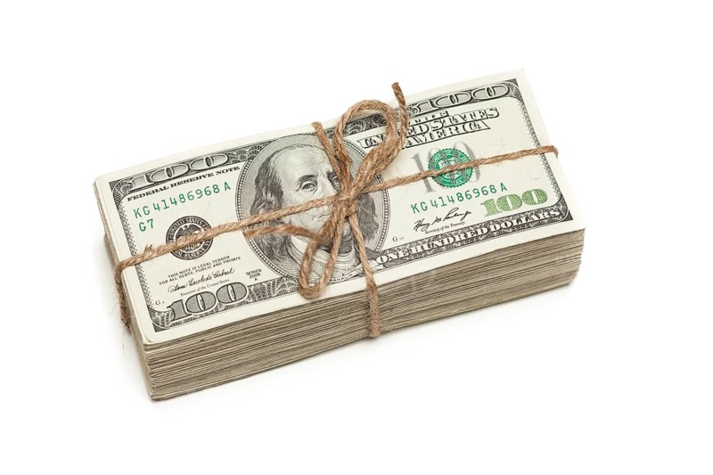 Stack of one hundred dollar bills tied in a burlap string isolated on a white background