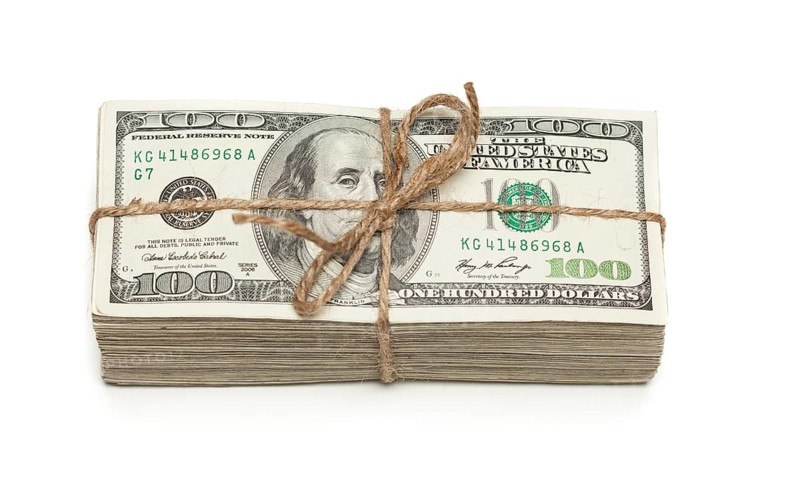 Stack of one hundred dollar bills tied in a burlap string isolated on a white background