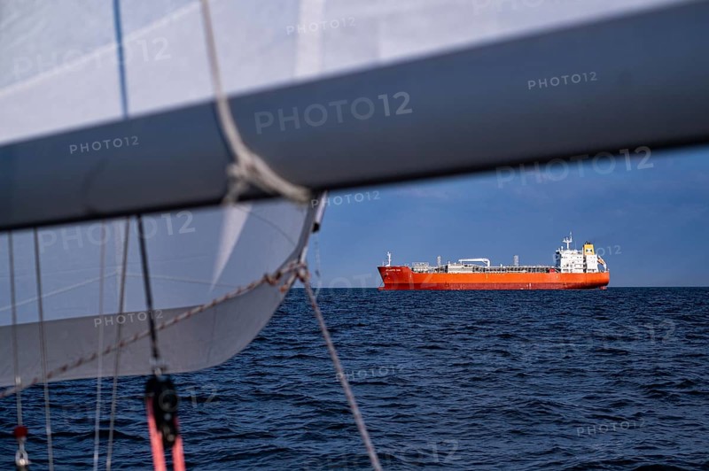 Sailing on the North Sea near Holland with freighter at anchor