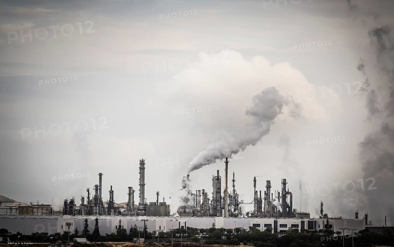 Working industrial plant with smoke stacks billowing smoke into the air