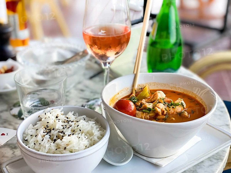 Asian soup in coconut sauce with shrimp and fish with rice