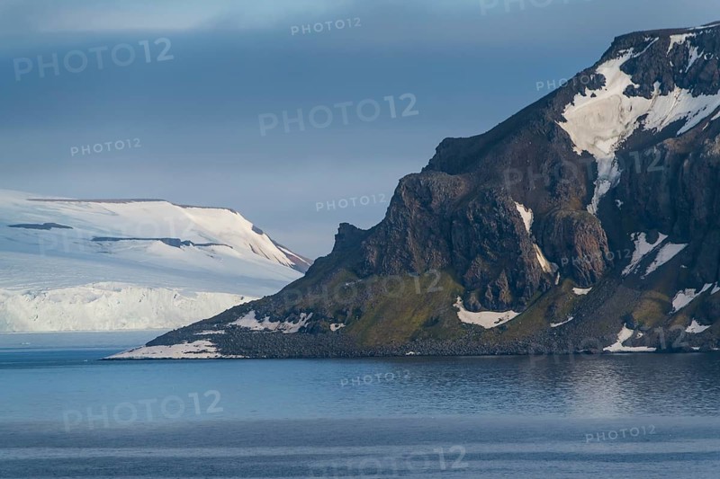 Green cliff in the glacier covered moutains of Franz Josef Land archipelago