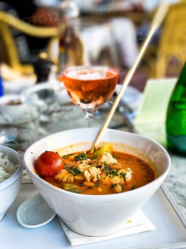 Asian soup in coconut sauce with shrimp and fish with rice