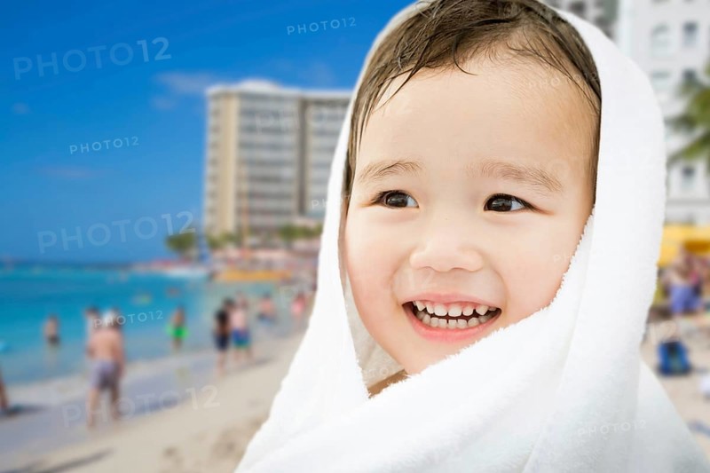Happy cute mixed-race chinese and caucasian boy on waikiki beach