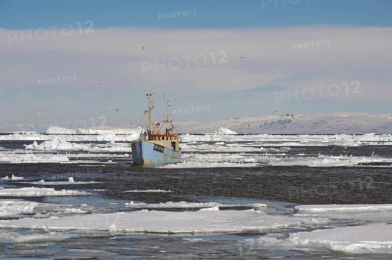 Blue fishing boat in drift ice