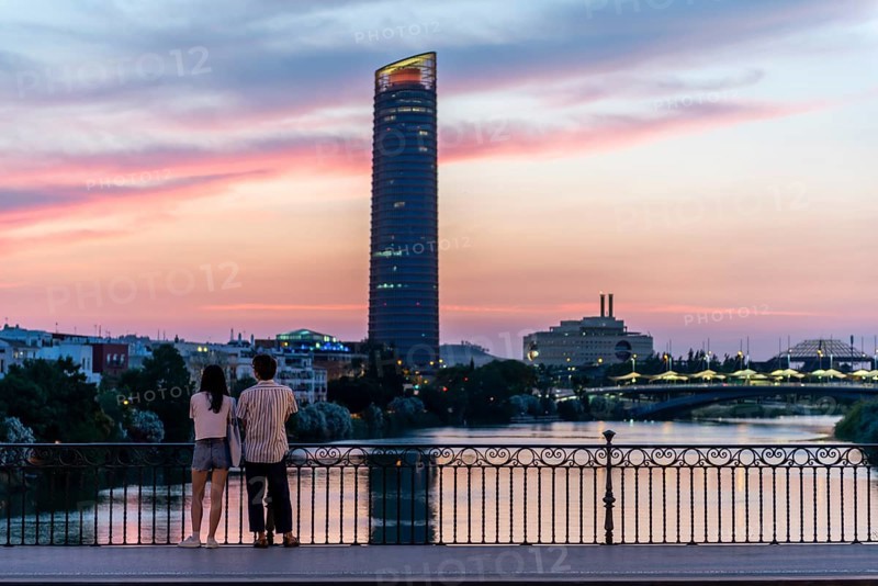Couple standing on the bridge at sunset