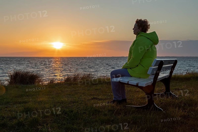 Woman enjoying the sunset on a bench