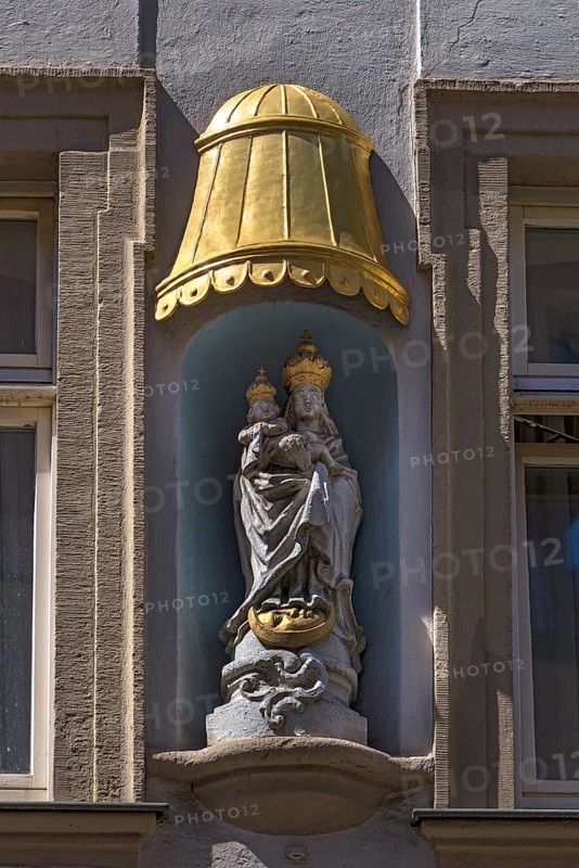 Sculpture of Maria immaculata under a gilded canopy on a residential building