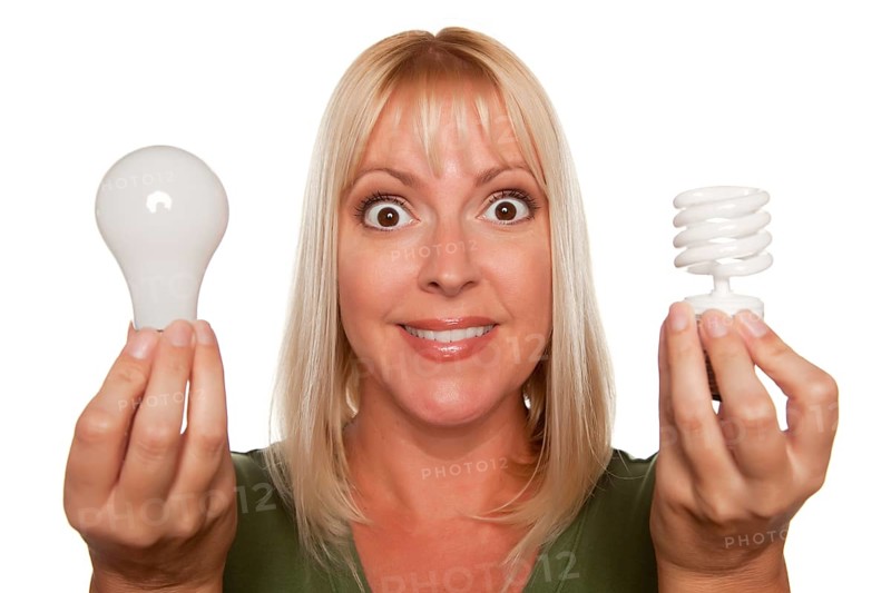 Woman holds energy saving and regular light bulbs isolated on a white background
