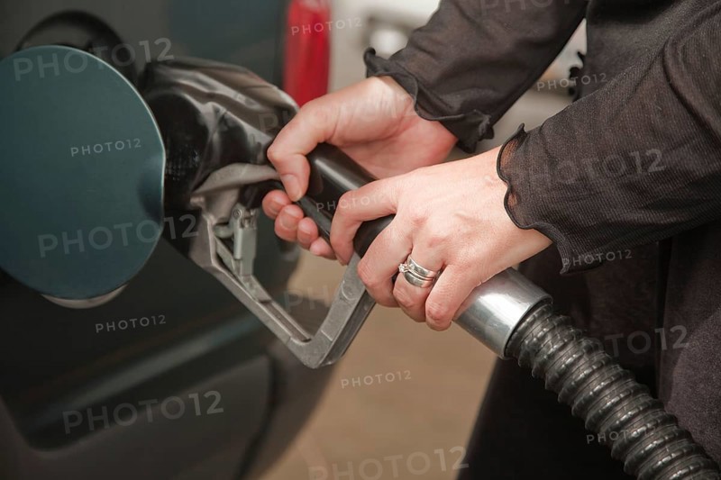 Woman's hands pumping gasoline at the service station