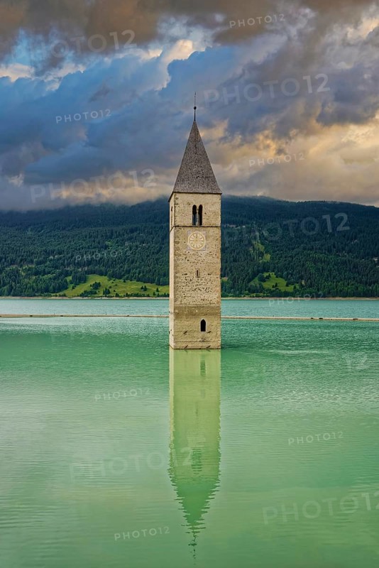 Church tower in the Reschensee with reflection