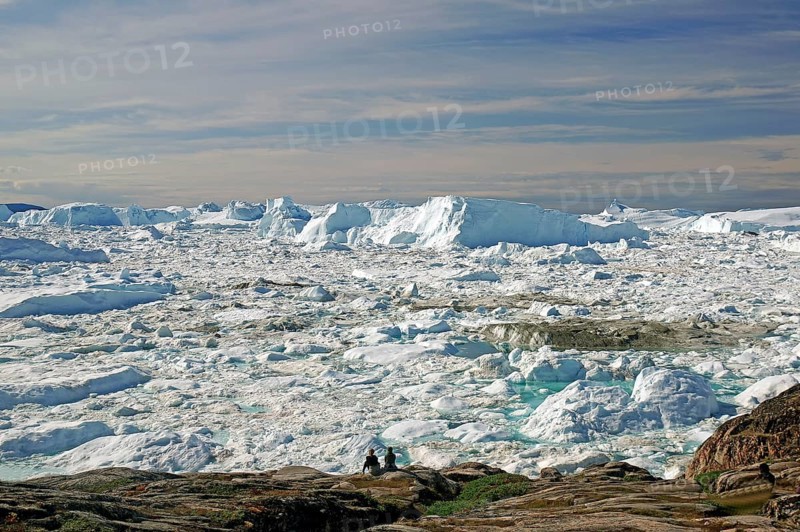 People in front of icebergs in fjord