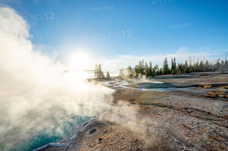 Steaming hot springs with turquoise water in the morning sun