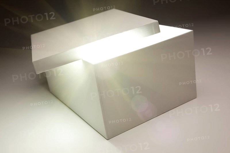 White box with lid revealing something very bright on a grey background