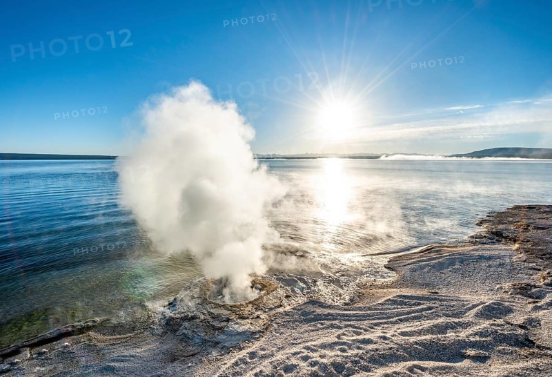 Steaming fumarole at the lake with morning sun