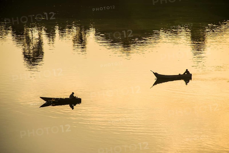 Fishermen in their canoes fishing at sunset on the Nile at Jinja source of the Nile