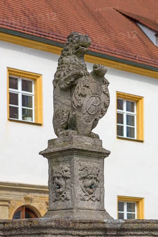 Lion with coat of arms as fountain figure in the castle courtyard