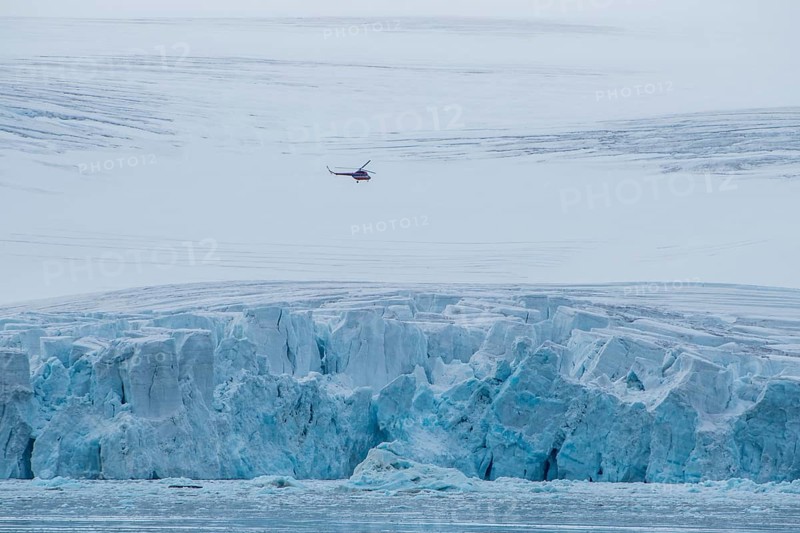 Helicopter flying over the giant icefield of Alexandra Land