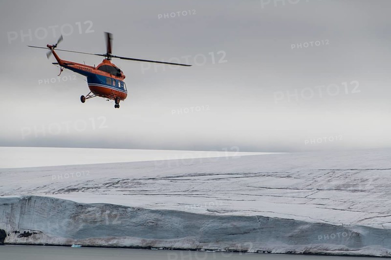 Helicopter flying over the giant icefield of Alexandra Land