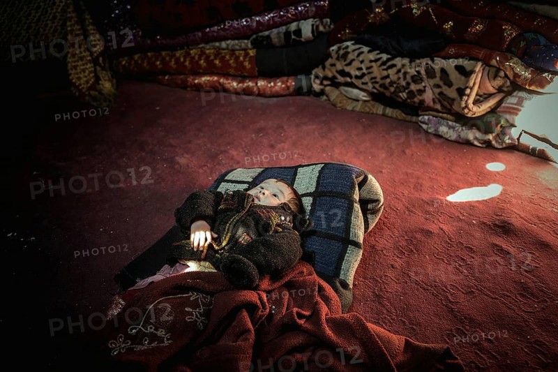 Toddler of a nomadic family lying on the floor in a yurt