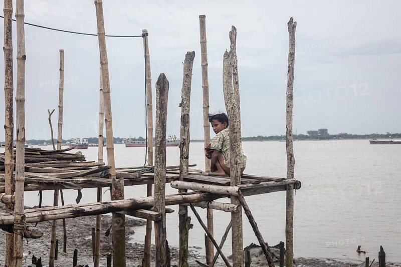A boy sits on a jetty