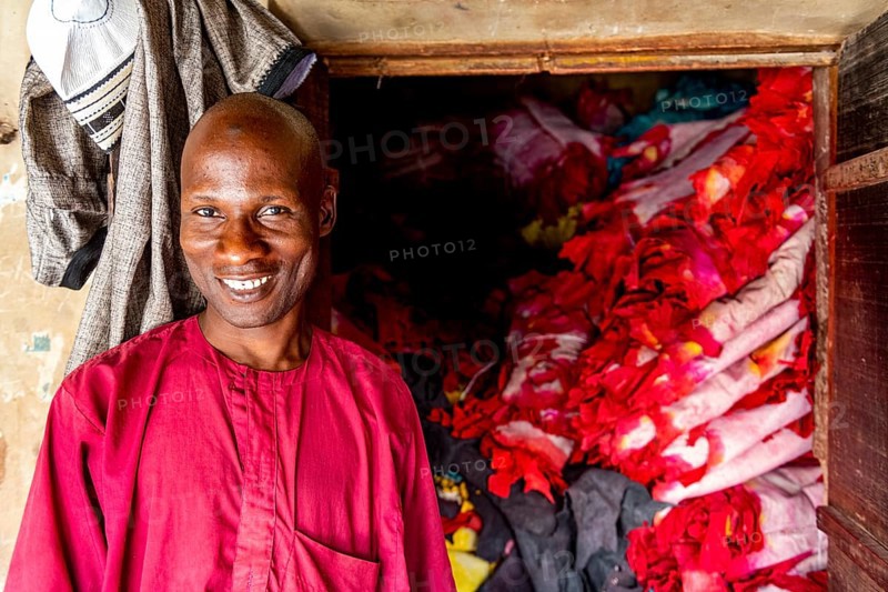 Shopkeeper before his shop full of colourful leather