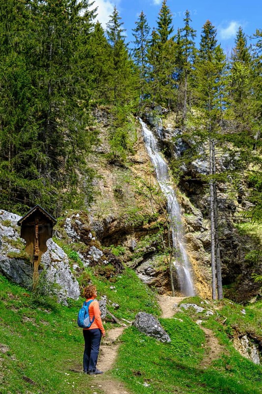 Hiker in front of the Arzmoos waterfall