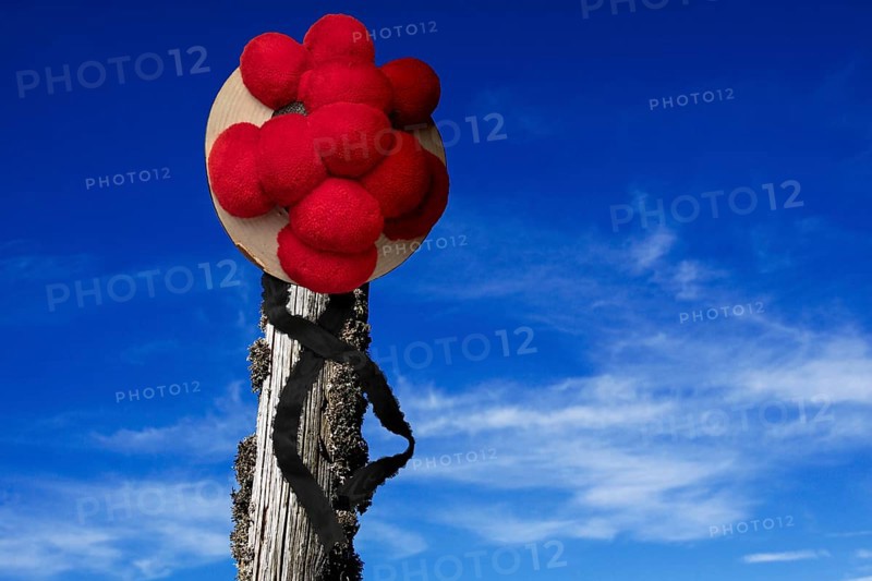 Original Black Forest Bollen hat on wooden post in front of blue sky