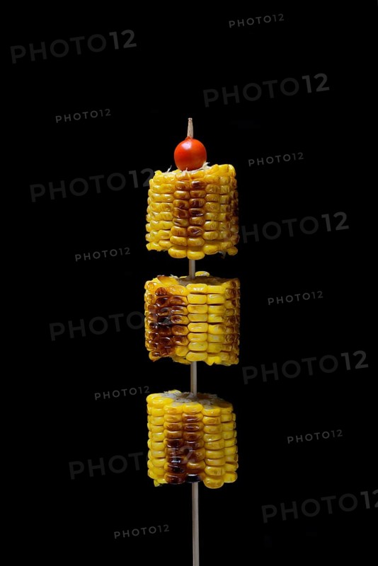 Grilled corn on the corn cob on a skewer