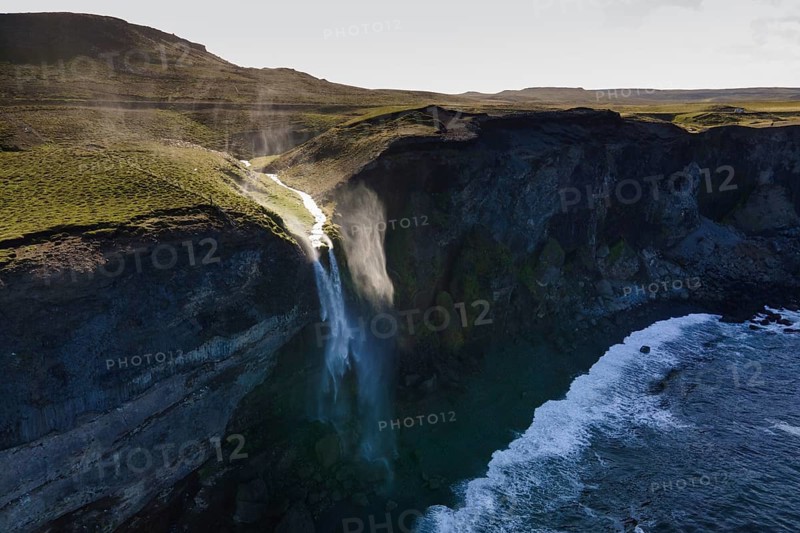 Waterfall at the sea is blown away by wind