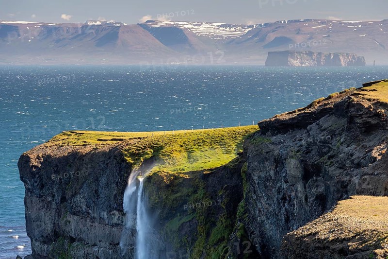 Waterfall falls over cliff and is blown away by wind